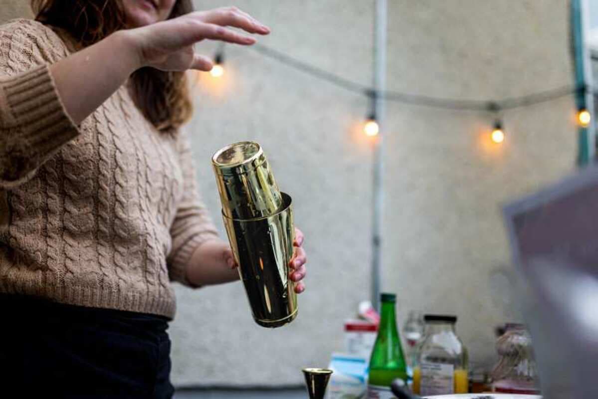 A bartender shaking a cocktail in a gold shaker